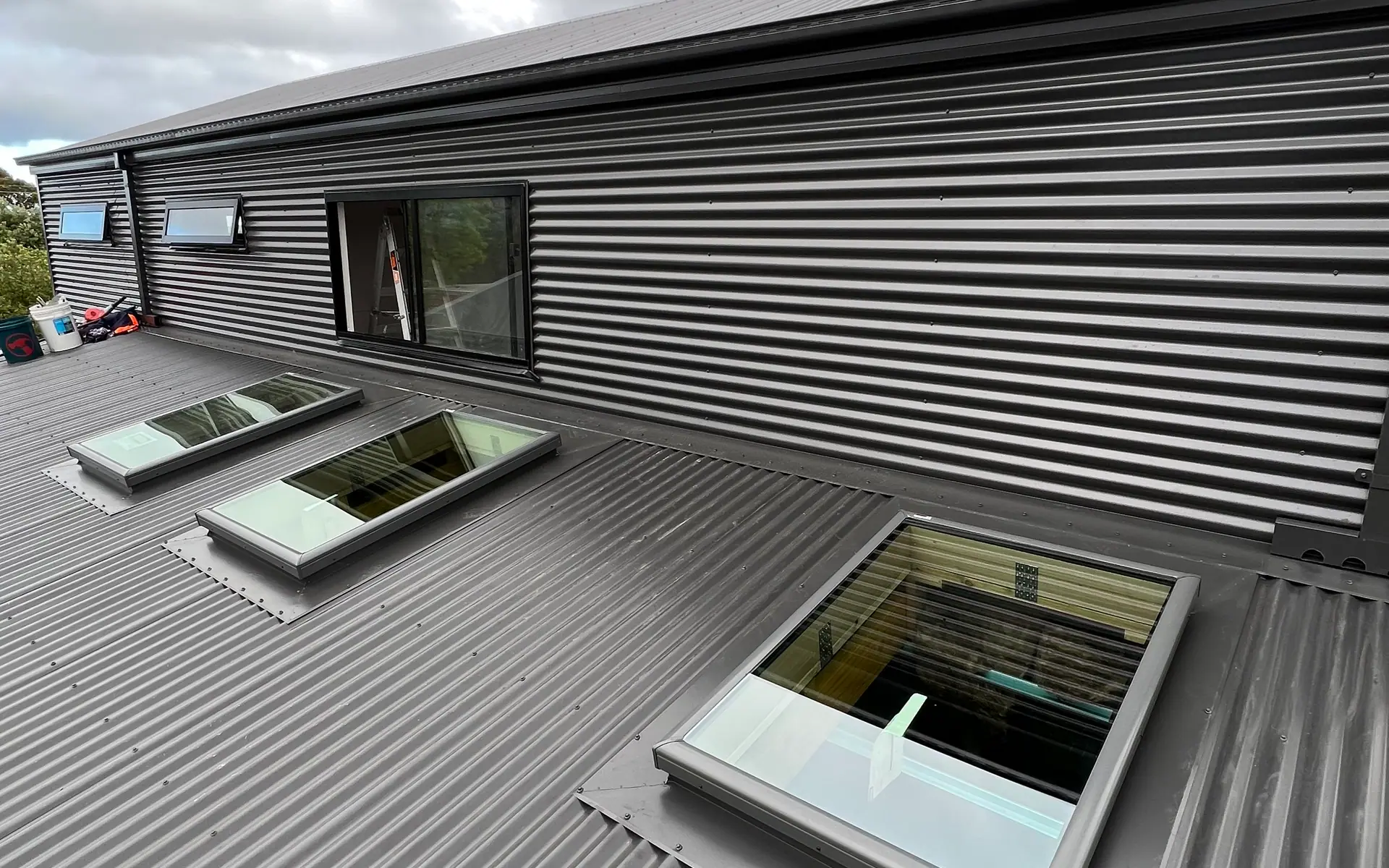 Metal wall cladding beside roof skylights